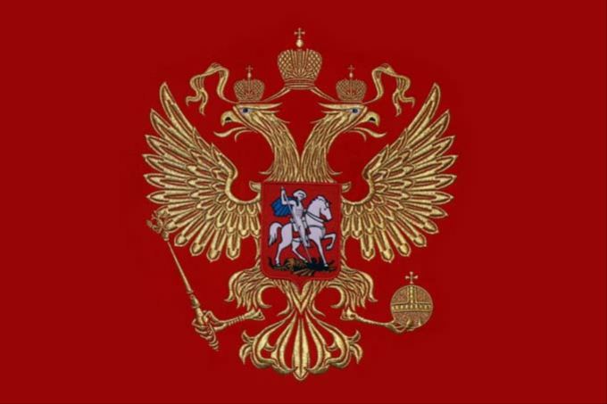 Вышивка герба золотим цветом на красной ткани